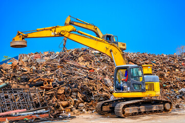 Excavator working recycled waste mountain in recycle factory