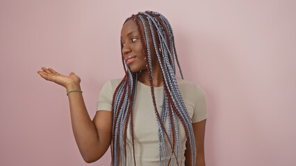 African american woman with braids over isolated pink background, extending her hand in a...