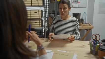 A surprised woman talks to a detective in an office with file folders, discussing a document case.