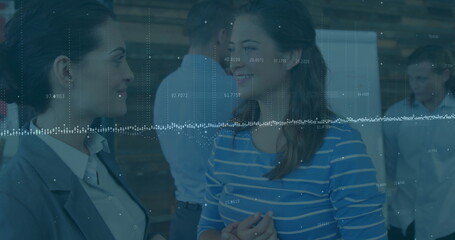 Image of statistical data processing over two diverse businesswomen discussing at office