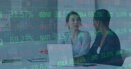 Image of statistics and financial data processing over diverse businesswomen in office
