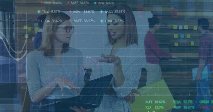 Image of stock market data processing over two diverse women discussing at office