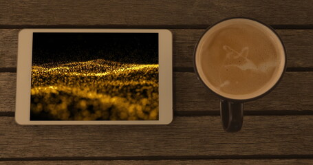 Image of smartphone with light trails on screen and cup of coffee on desk