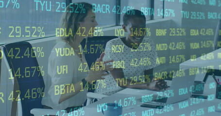 Image of stock market data processing over two diverse women discussing over a laptop at office