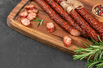 Polish kabanosy thin dry sausages on a wooden board, top view. copy space