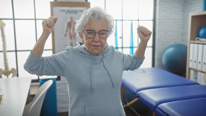 A senior woman exercises in a physiotherapy clinic's interior, showcasing determination and health.