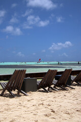 Deckchairs at white sandy Caribbean beach with windsurfers in the distance, Sorobon, Bonaire, Caribbean Netherlands