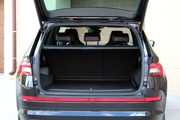 The car is ready to load luggage. Modern black SUV open trunk. Clean trunk SUV car. Open back door modern SUV. Car open trunk. Car boot is open.
