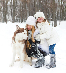 Fototapeta na wymiar Mother with daughter with huskies dog