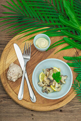 Rapana clam meat with oil, spices and greens. Healthy seafood is rich in omega. Marine decor