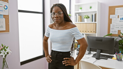Confident african american woman with braids standing in a modern office