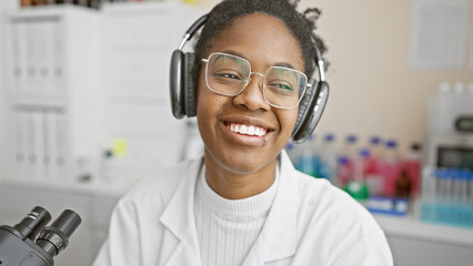African american woman scientist with headphones in laboratory