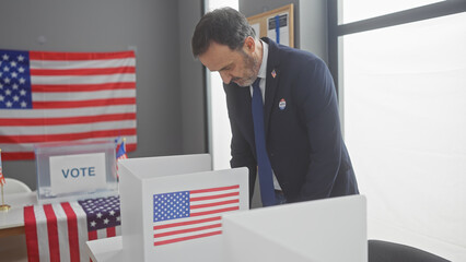 Mature bearded man voting in american electoral room with flags