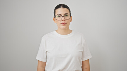 Young beautiful hispanic woman standing with serious expression over isolated white background
