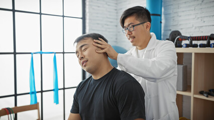 A male physiotherapist treating a patient's neck in a well-lit, modern physiotherapy clinic.