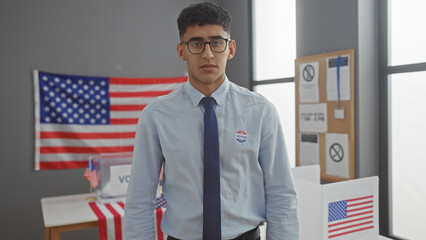 A young man stands confidently in a polling station with an 'i voted' sticker, symbolizing american democracy.