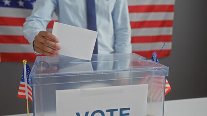 A man casting a vote in an american election with a ballot box and us flags, representing democracy and citizenship.