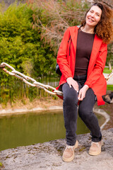 Portrait of beautiful young woman wearing red jacket outdoors - 785357395