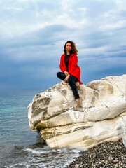 girl in a red jacket on the seashore - 785357510