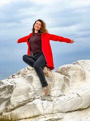 girl in a red jacket on the seashore - 785357518