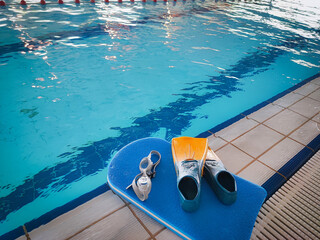 Resistant equipment - fins, swimming goggles, rescue board on the side near the pool. Preparing...