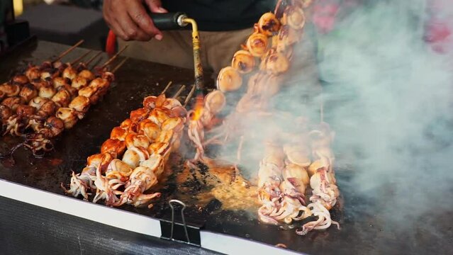a man stirring an octopus satay at the Ramadan Bazzar