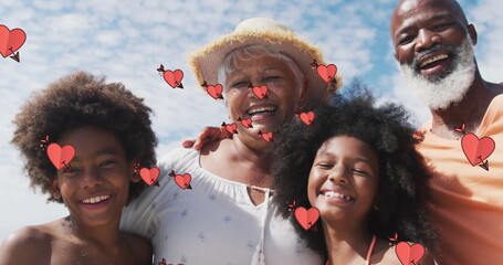 Image of hearts over smiling african american family smiling and embracing