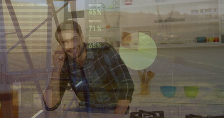 Image of statistical data processing over caucasian man talking on smartphone at home