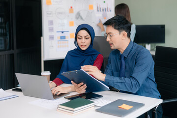 Happy businesspeople while collaborating on a new project in an office. Group of diverse businesspeople using a laptop and tablet