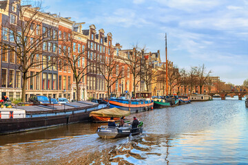 Cityscape on a sunny winter day - view of the water canal in the historic center of Amsterdam, the Netherlands
