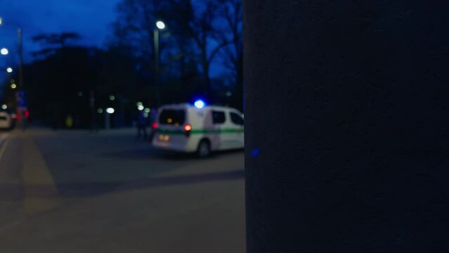 Blurred image of a police car with bright emergency lights patrolling the city center