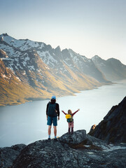 Family father and child hiking in mountains of Norway together exploring Kvaloya island adventure healthy lifestyle outdoor active vacations dad with daughter enjoying fjord view - obrazy, fototapety, plakaty