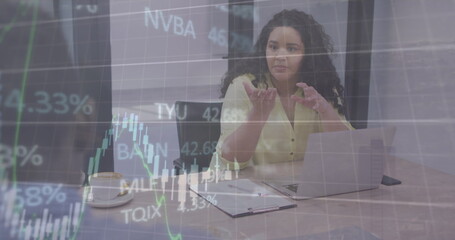 Image of graphs and financial data over biracial woman in office
