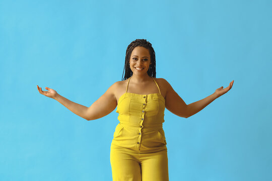 portrait of thankful happy young adult beautiful african american woman with braid hair posing at studio with hands open
