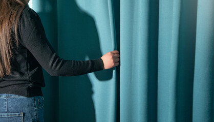 Woman correcting curtain at home.