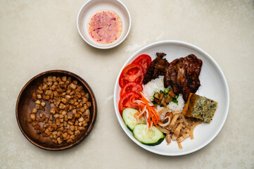 Cơm Tấm. Vietnamese Broken rice with grilled pork, steamed egg, and fresh vegetable