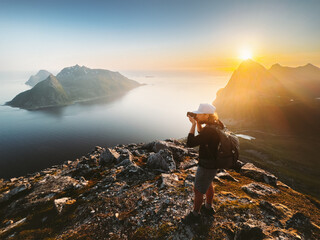Man photographer travel blogger taking photo by camera of landscape in Norway tourist traveling hiking with backpack summer vacations healthy lifestyle outdoor content creator - 785382130