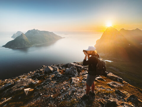 Man photographer travel blogger taking photo by camera of landscape in Norway tourist traveling hiking with backpack summer vacations healthy lifestyle outdoor content creator