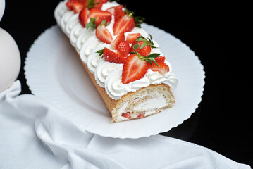 sponge roll with cream, decorated with fresh strawberries
