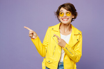 Young happy smiling woman wears yellow shirt white t-shirt casual clothes glasses point indicate on...