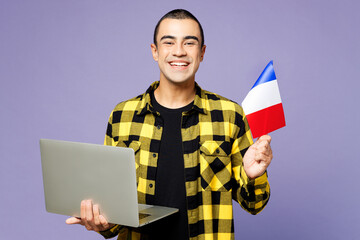 Young student IT middle eastern man wear yellow shirt casual clothes hold French flag use work on...