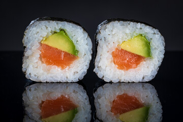 Sushi rolls with tuna and avocado. Sushi with reflection. Traditional japanese food
