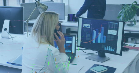 Image of financial data processing over caucasian woman talking on smartphone at office - Powered by Adobe