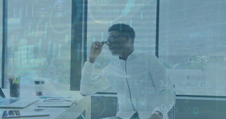 Image of statistical data processing over thoughtful african american man at office - Powered by Adobe