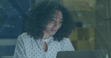 Image of graphs and escalator over thoughtful biracial woman writing notes on laptop