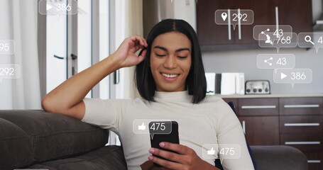 Image of social media icons and numbers over biracial woman using smartphone