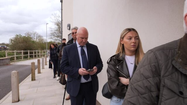 4K: People stand in line outside stood waiting.  People queuing up looking impatient. Stock Video Clip Footage