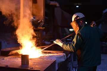 young worker in protective clothing at work at the blast furnace in an iron foundry - 785398161