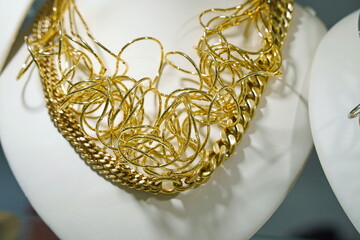A necklace made of gold is hung on the stand.