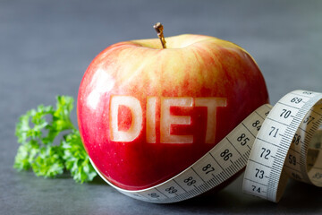 Red apple with cut-out word diet and measuring tape, diet and healthy lifestyle concept